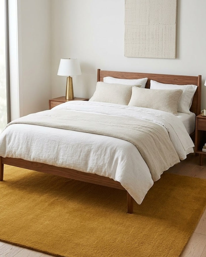 Liso Gold solid hand-tufted wool rug under a bed