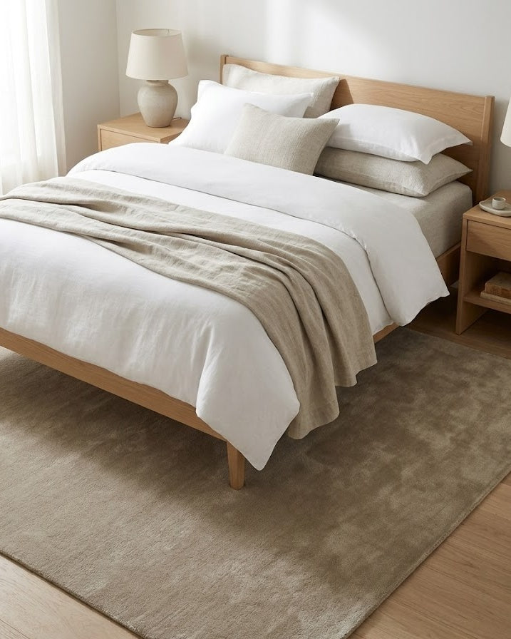 Liso Khaki solid hand-tufted wool rug under a bed
