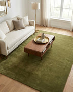 Liso Olive solid hand-tufted wool rug in a bright living room