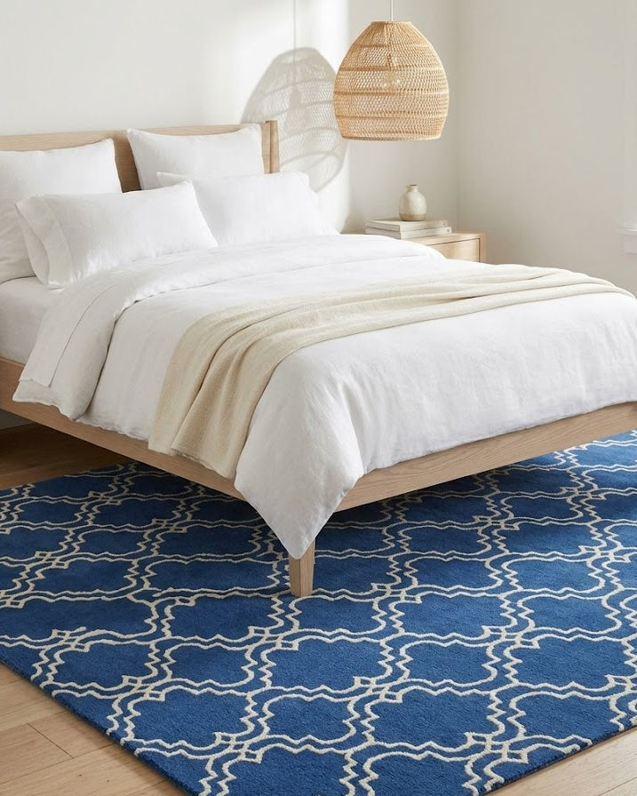 Scroll Tile Moroccan wool rug in blue and ivory under a bed