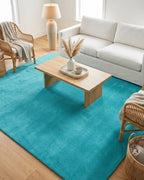 Liso Turquoise solid hand-tufted wool rug in a bright living room